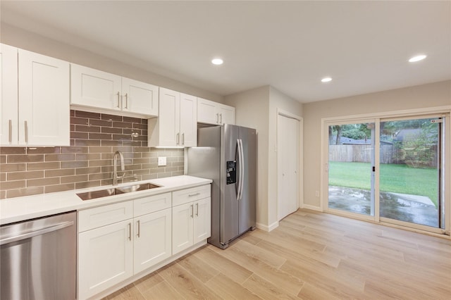 22843 Post Gate Dr, Spring, TX 77373 - kitchen featuring stainless steel appliances, light countertops, light wood-style flooring, white cabinets, and recessed lighting