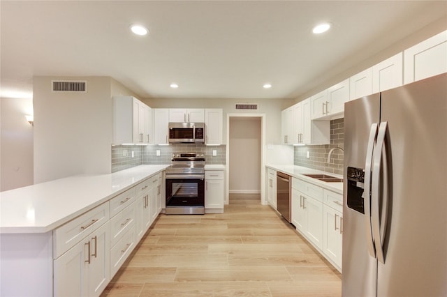 22843 Post Gate Dr, Spring, TX 77373 - kitchen with stainless steel appliances, a peninsula, decorative backsplash, light countertops, and recessed lighting