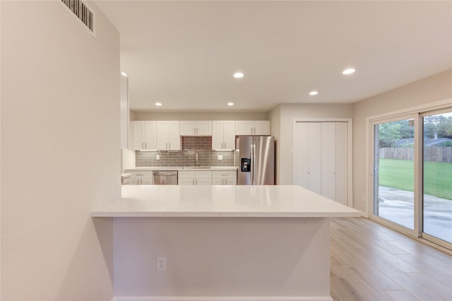 22843 Post Gate Dr, Spring, TX 77373 - kitchen with appliances with stainless steel finishes, light countertops, white cabinets, a peninsula, and recessed lighting
