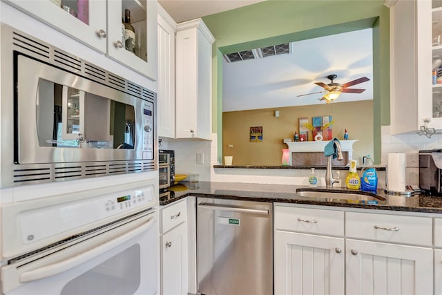 2605 Broussard Ct, Seabrook, TX 77586 - kitchen with stainless steel appliances, tasteful backsplash, ceiling fan, and dark stone counters