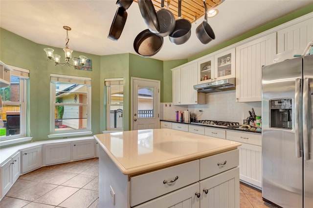 2605 Broussard Ct, Seabrook, TX 77586 - kitchen with appliances with stainless steel finishes, light tile patterned floors, under cabinet range hood, a chandelier, and backsplash