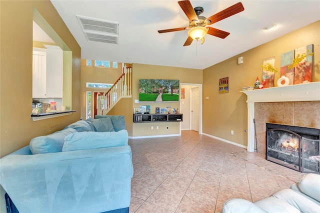 2605 Broussard Ct, Seabrook, TX 77586 - living room featuring a ceiling fan, stairs, a tile fireplace, and light tile patterned floors