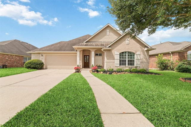 28035 Emma Gardens Ln, Spring, TX 77386 - view of front of property featuring brick siding, an attached garage, driveway, a front yard, and a shingled roof