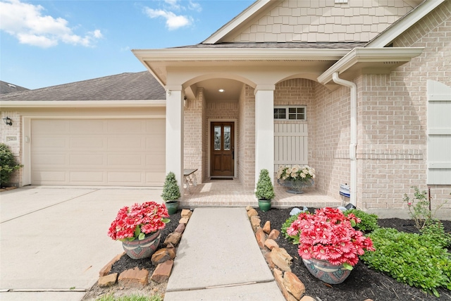 28035 Emma Gardens Ln, Spring, TX 77386 - property entrance featuring brick siding, a garage, driveway, covered porch, and a shingled roof
