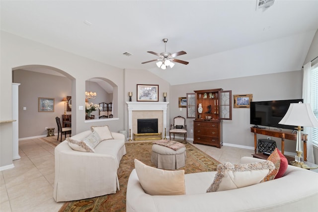 28035 Emma Gardens Ln, Spring, TX 77386 - living area with tile patterned flooring, a ceiling fan, arched walkways, lofted ceiling, and a tiled fireplace