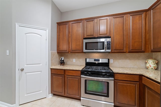 28035 Emma Gardens Ln, Spring, TX 77386 - kitchen with appliances with stainless steel finishes, tasteful backsplash, and brown cabinets