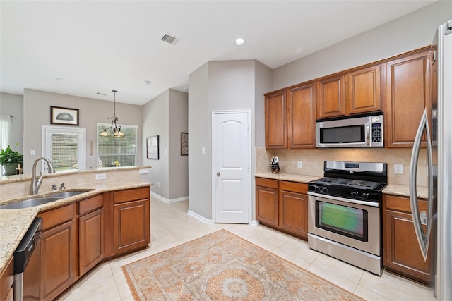 28035 Emma Gardens Ln, Spring, TX 77386 - kitchen with appliances with stainless steel finishes, brown cabinetry, light stone countertops, and recessed lighting