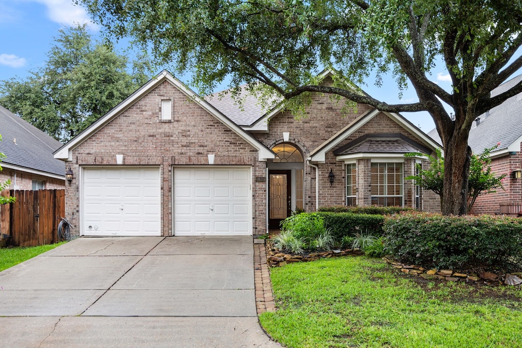 6930 Afton Woods Dr, Houston, TX 77055 - view of front of house with brick siding, driveway, and a garage