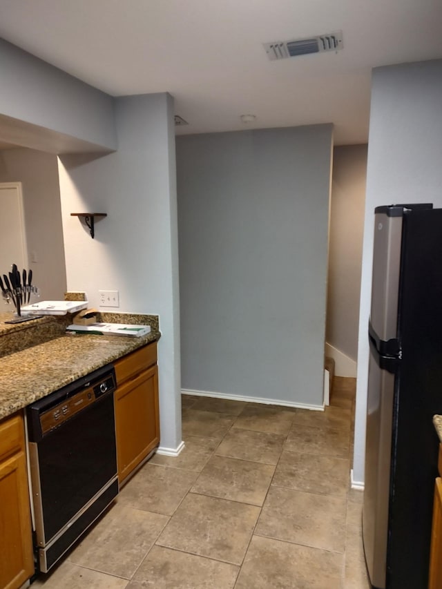 3125 Hells Gate Loop Unit 29, Strawn, TX 76475 - kitchen with freestanding refrigerator, dishwasher, light tile patterned floors, stone counters, and brown cabinets
