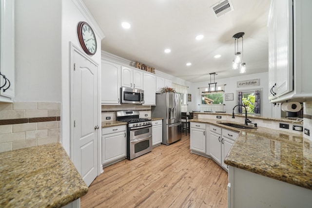 6107 Kyle Bend Ln, Katy, TX 77493 - kitchen featuring appliances with stainless steel finishes, tasteful backsplash, pendant lighting, white cabinetry, and recessed lighting