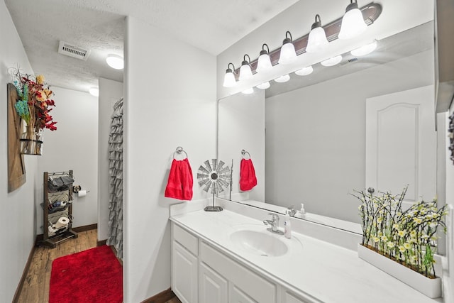6107 Kyle Bend Ln, Katy, TX 77493 - bathroom with vanity, wood finished floors, a textured ceiling, and a shower with shower curtain