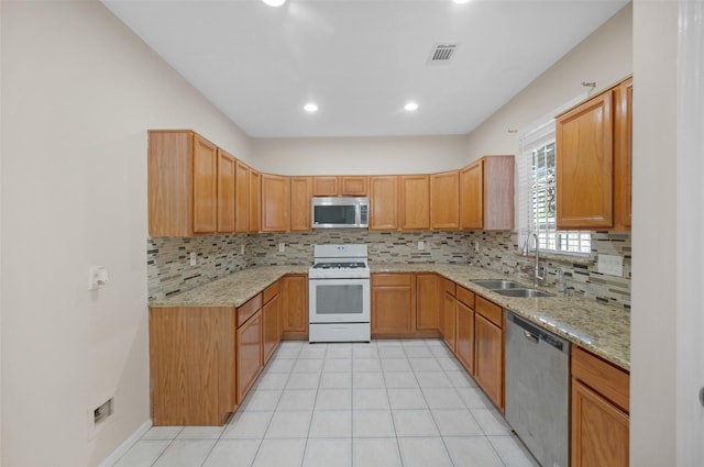 13535 San Martin Ln, Houston, TX 77083 - kitchen featuring appliances with stainless steel finishes, tasteful backsplash, light stone countertops, light tile patterned floors, and recessed lighting