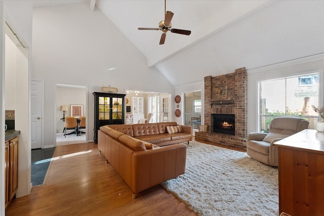 8411 Lylewood Ct, Houston, TX 77040 - living room with light wood-style floors, a fireplace, high vaulted ceiling, beam ceiling, and a ceiling fan