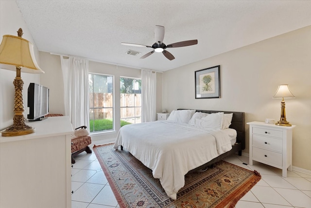8411 Lylewood Ct, Houston, TX 77040 - bedroom with light tile patterned flooring, ceiling fan, and a textured ceiling
