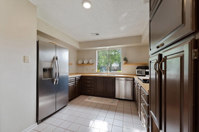 8411 Lylewood Ct, Houston, TX 77040 - kitchen with stainless steel appliances, open shelves, a textured ceiling, light countertops, and light tile patterned floors