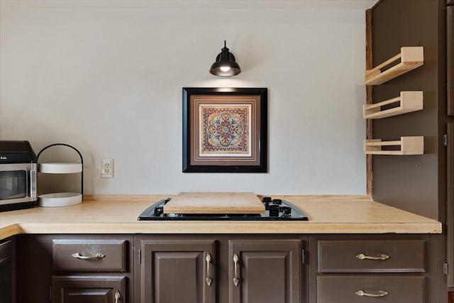 8411 Lylewood Ct, Houston, TX 77040 - detailed view of cooktop, light countertops, dark brown cabinetry, and open shelves