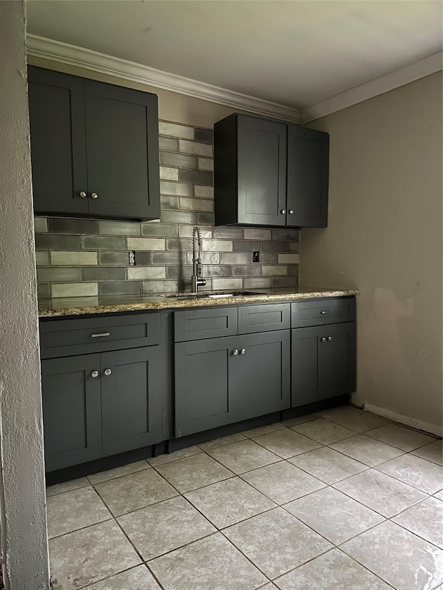 4730 Angleton St, Houston, TX 77033 - kitchen with gray cabinets, crown molding, light tile patterned floors, decorative backsplash, and stone counters