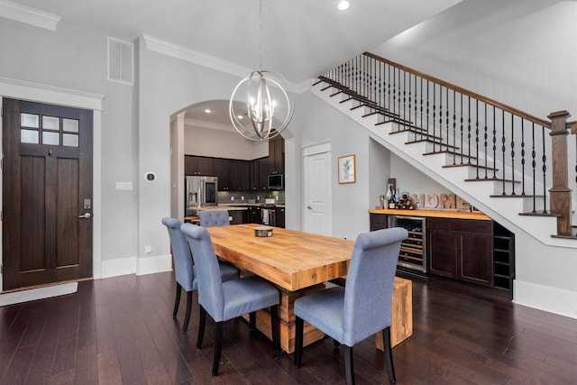 5825 Petty St, Houston, TX 77007 - dining area with beverage cooler, ornamental molding, a chandelier, dark wood-style floors, and stairway