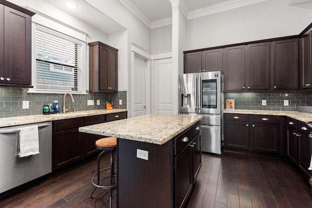 5825 Petty St, Houston, TX 77007 - kitchen with appliances with stainless steel finishes, dark wood-style floors, crown molding, and dark brown cabinetry