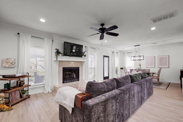 10603 Wagon Trail Rd, Houston, TX 77064 - living room featuring ornamental molding, a tile fireplace, light wood-style floors, ceiling fan, and healthy amount of natural light