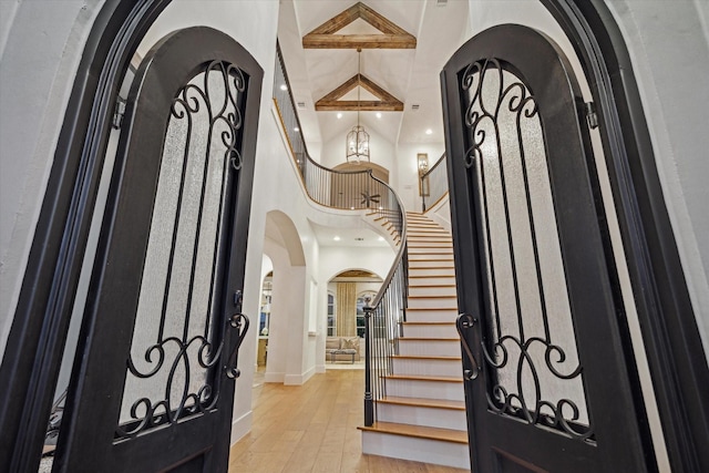 3835 Merrick St, Houston, TX 77025 - foyer featuring arched walkways, a high ceiling, hardwood / wood-style flooring, stairs, and recessed lighting
