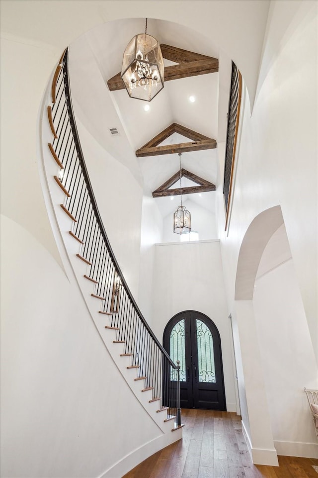 3835 Merrick St, Houston, TX 77025 - entrance foyer featuring a chandelier, french doors, high vaulted ceiling, stairs, and arched walkways