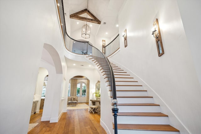 3835 Merrick St, Houston, TX 77025 - stairway featuring a towering ceiling, arched walkways, hardwood / wood-style flooring, a chandelier, and recessed lighting