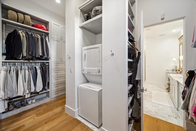 3835 Merrick St, Houston, TX 77025 - laundry area featuring stacked washer / drying machine, light wood-style floors, and recessed lighting