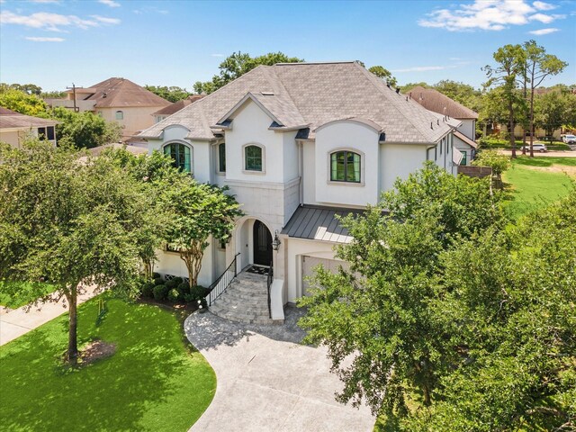3835 Merrick St, Houston, TX 77025 - french provincial home featuring a standing seam roof, an attached garage, roof with shingles, a front lawn, and a metal roof