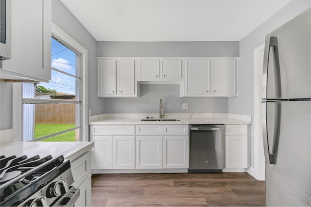 1705 13th St, Galena Park, TX 77547 - kitchen with appliances with stainless steel finishes, light countertops, white cabinetry, and dark wood-style flooring