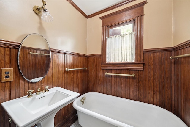 519 Bayland Ave, Houston, TX 77009 - bathroom featuring wainscoting, a soaking tub, crown molding, and wood walls