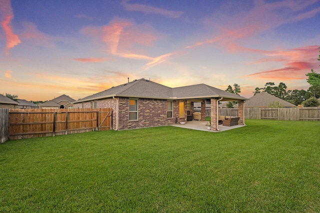 18015 Van Berkel Ln, Houston, TX 77044 - back of house at dusk with a patio, a fenced backyard, an outdoor hangout area, brick siding, and roof with shingles