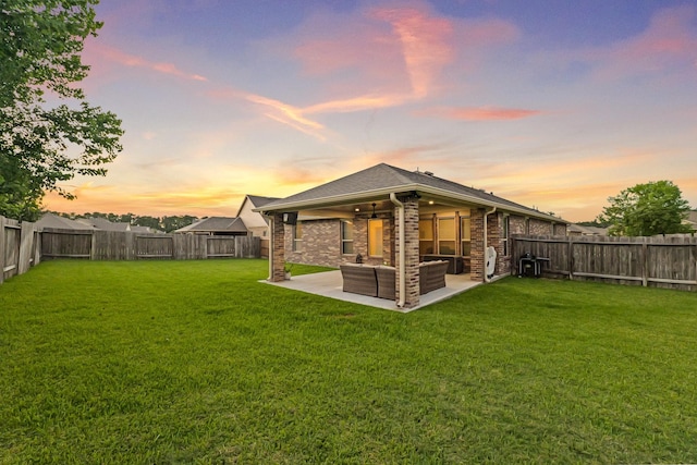 18015 Van Berkel Ln, Houston, TX 77044 - back of house at dusk with a fenced backyard, a patio area, an outdoor hangout area, and brick siding