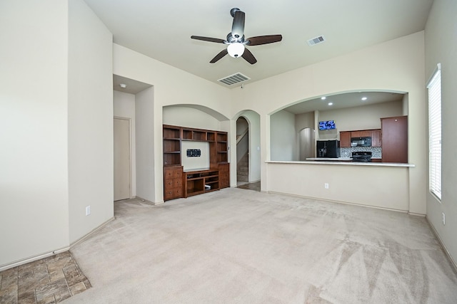 20603 Flintoff Ln, Katy, TX 77449 - unfurnished living room with arched walkways, plenty of natural light, a ceiling fan, and light carpet