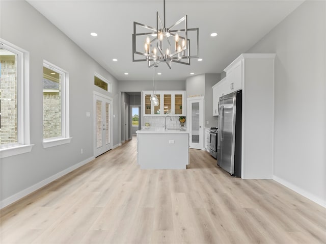 1200 Sailfish Dr, Bay City, TX 77414 - kitchen with stainless steel appliances, light countertops, a kitchen island with sink, white cabinetry, and a chandelier
