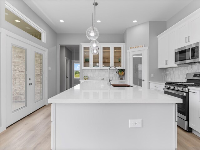 1200 Sailfish Dr, Bay City, TX 77414 - kitchen with appliances with stainless steel finishes, french doors, backsplash, light wood-style flooring, and recessed lighting