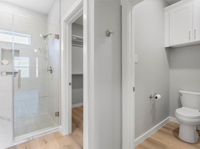 1200 Sailfish Dr, Bay City, TX 77414 - bathroom with a marble finish shower, a walk in closet, and wood finished floors