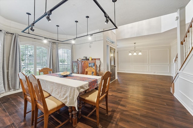 7938 S Wellington Ct, Houston, TX 77055 - dining space featuring rail lighting, dark wood-style floors, a decorative wall, and a chandelier