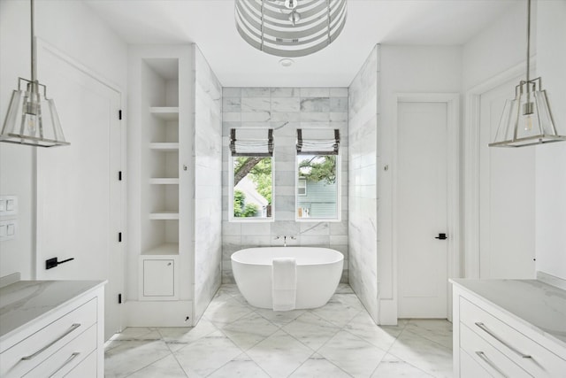 1220 Bomar St, Houston, TX 77006 - bathroom with marble finish flooring, a soaking tub, vanity, and built in shelves
