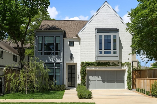 1220 Bomar St, Houston, TX 77006 - view of front facade with brick siding, concrete driveway, a garage, and roof with shingles