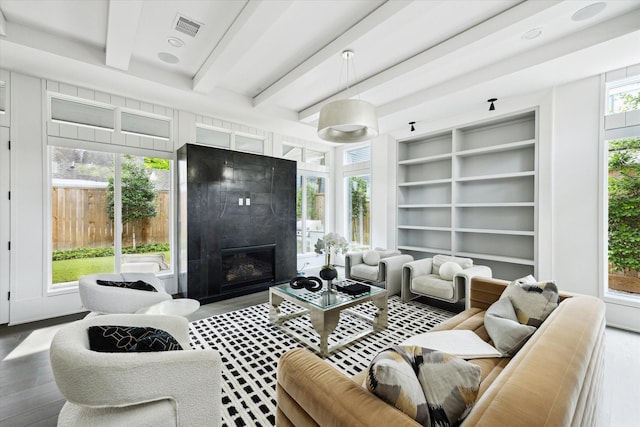 1220 Bomar St, Houston, TX 77006 - living room with beamed ceiling, a premium fireplace, wood finished floors, and built in shelves