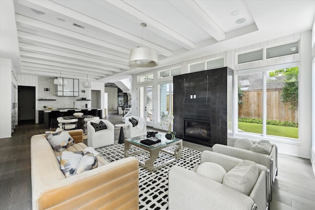 1220 Bomar St, Houston, TX 77006 - living area featuring healthy amount of natural light, dark wood finished floors, beamed ceiling, and a fireplace
