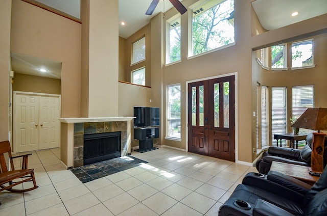 4415 Crimson Ct, Sugar Land, TX 77479 - entrance foyer featuring a high ceiling, healthy amount of natural light, light tile patterned flooring, a ceiling fan, and a fireplace