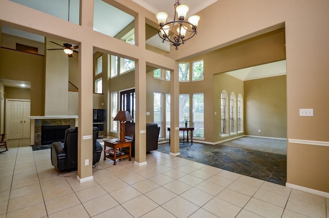 4415 Crimson Ct, Sugar Land, TX 77479 - entryway with a tile fireplace, crown molding, a chandelier, a towering ceiling, and a ceiling fan