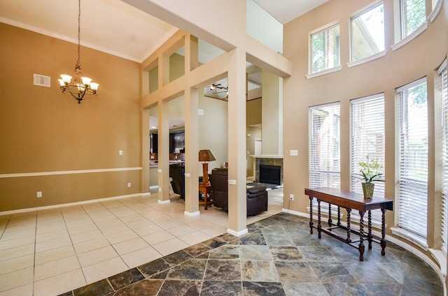 4415 Crimson Ct, Sugar Land, TX 77479 - foyer featuring a high ceiling, a tile fireplace, a chandelier, and ornamental molding