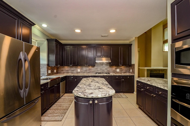 4415 Crimson Ct, Sugar Land, TX 77479 - kitchen with appliances with stainless steel finishes, ornamental molding, light tile patterned floors, tasteful backsplash, and under cabinet range hood