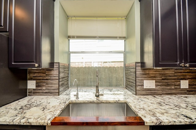 4415 Crimson Ct, Sugar Land, TX 77479 - kitchen with decorative backsplash, dark brown cabinets, and light stone countertops