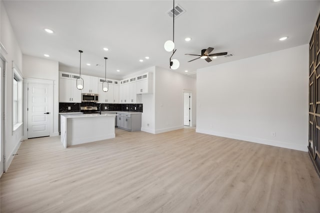 4825 Pederson St A/B, Unit A/B Houston, TX 77033 - kitchen with stainless steel microwave, open floor plan, recessed lighting, tasteful backsplash, and black / electric stove