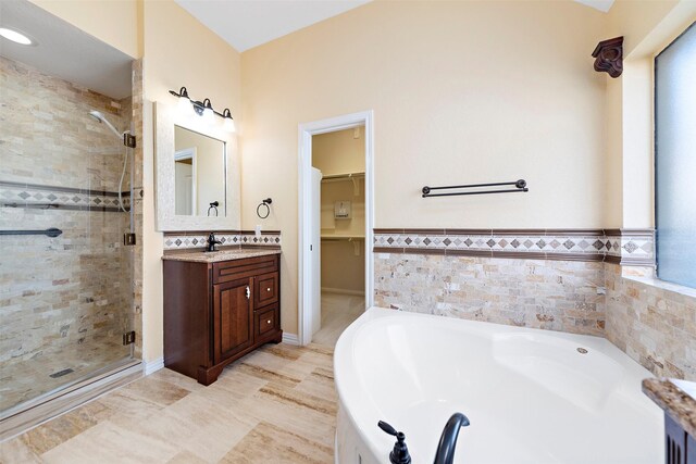 3318 Misty Alcove Ct, Kingwood, TX 77345 - bathroom with a stall shower, vanity, a garden tub, a walk in closet, and wainscoting