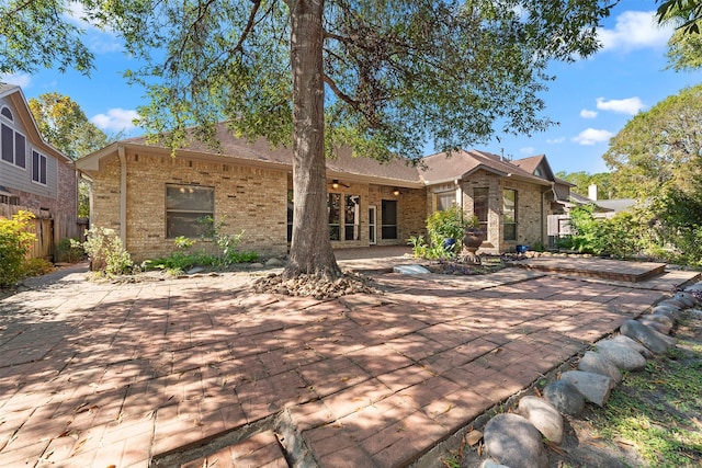 3318 Misty Alcove Ct, Kingwood, TX 77345 - back of property featuring brick siding and a patio